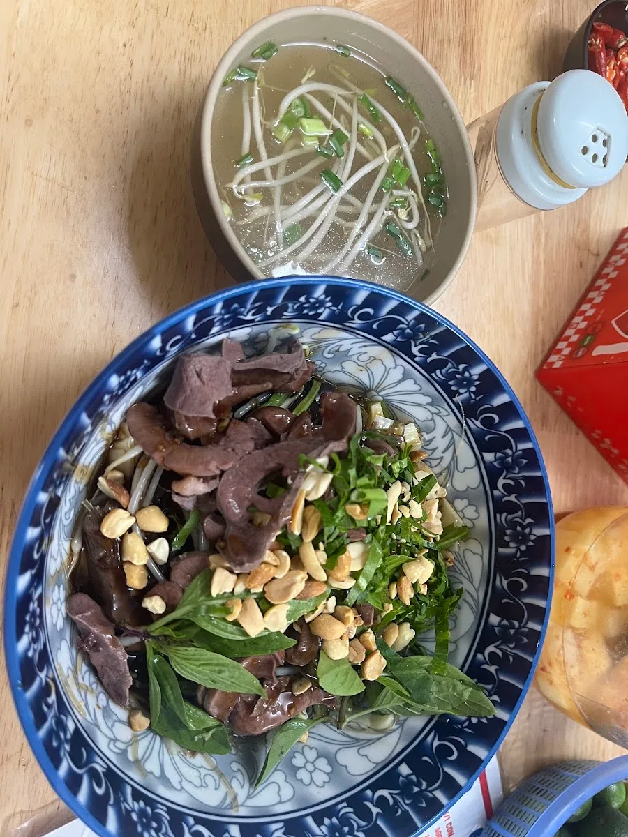 Đĩa trộn đảo đều tay, sốt thấm, rắc lạc rang và rau thơm
